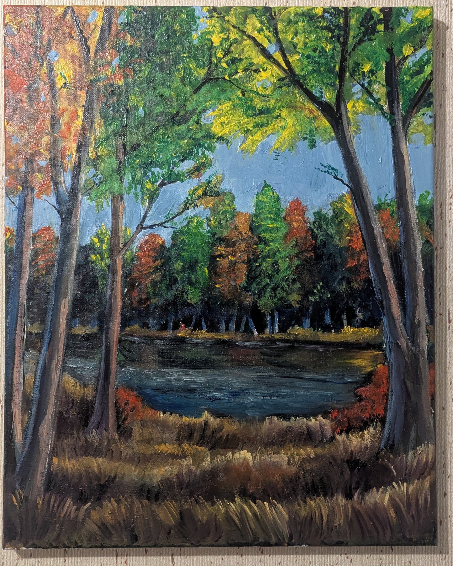 Painting of a forest scene with trees and a pond on a textured wall.