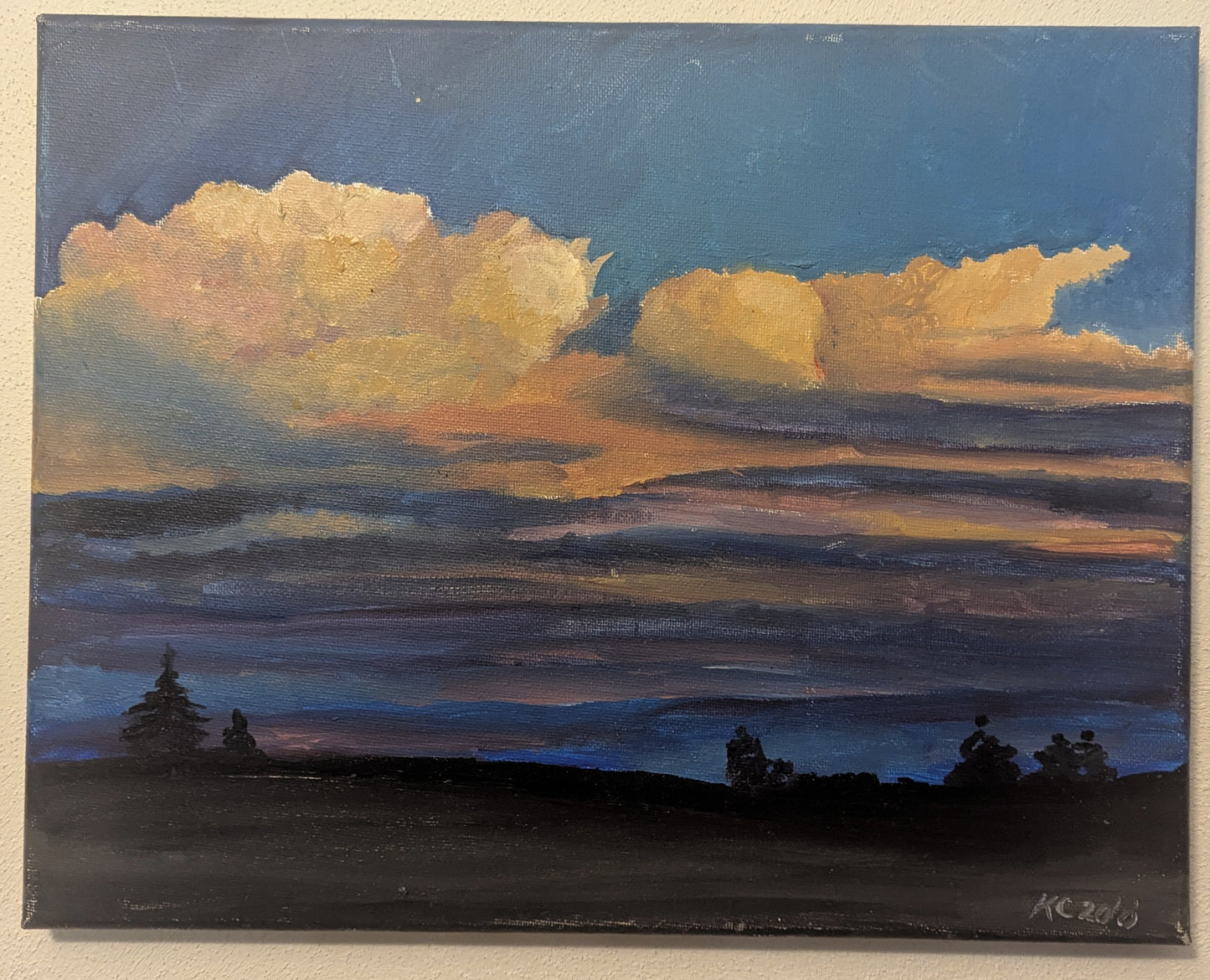 Painting of a sunset with clouds on a beige wall